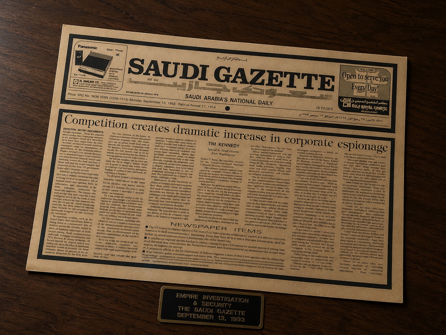 The Saudi Gazette front page displayed on a dark wood desk